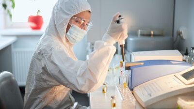 Scientist in a hazmat suit conducting research on a highly pathogenic coronavirus