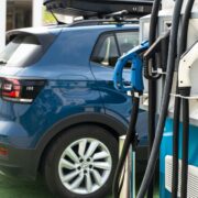 Electric car on gas station. Blue car and electric plug for char