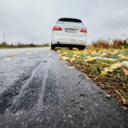 Emergency braking of white car on road outside city.